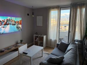 een woonkamer met een bank en een tafel bij superbe duplex avec parking gratuit in Grenoble