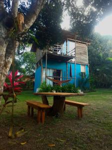 een blauw huis met een picknicktafel en een bank bij Casa Ganesha in Itacaré