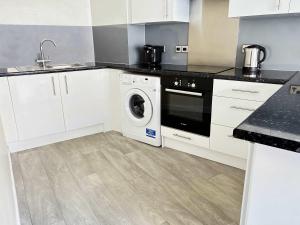 een keuken met een wasmachine en een wastafel bij York City Centre Flat with view - Best Location - Walk to Everything in York