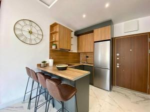 eine Küche mit einer Theke und einer Uhr an der Wand in der Unterkunft Elia Residence Rooms in Becici