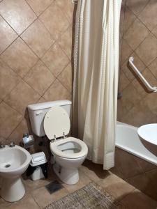 een badkamer met een toilet, een wastafel en een douche bij Complejo El Guri in Colón