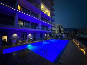 a swimming pool in front of a building at night at Elia Residence Rooms in Bečići