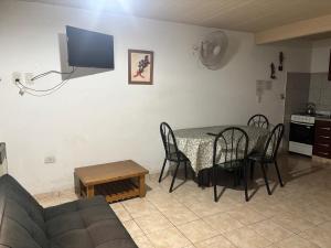 een woonkamer met een tafel en stoelen en een televisie bij Complejo El Guri in Colón