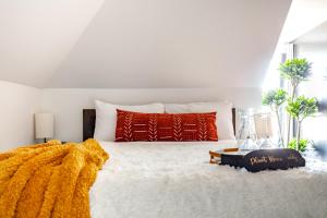 ein Schlafzimmer mit einem großen weißen Bett mit einer Decke darauf in der Unterkunft Jungle House Columbus - Luxury Downtown Homes Free Parking in Columbus