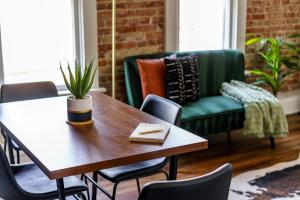 ein Wohnzimmer mit einem Tisch und einer grünen Couch in der Unterkunft Jungle House Columbus - Luxury Downtown Homes Free Parking in Columbus + 48 Fotos