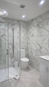 a bathroom with a toilet and a glass shower at Royal House by Bourne Hall in Bournemouth +26 photos