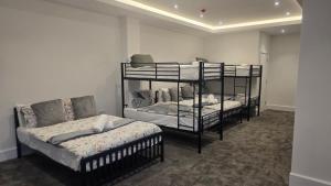 a room with three bunk beds and a couch at Royal House by Bourne Hall in Bournemouth