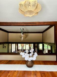 een vaas met bloemen in een kamer met een spiegel bij Casa da Tartaruga Búzios in Búzios +93 foto's