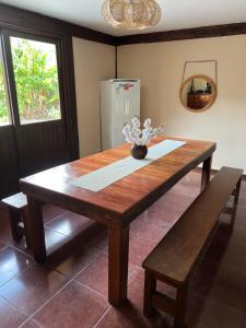 een houten tafel met een vaas met bloemen erop bij Casa da Tartaruga Búzios in Búzios