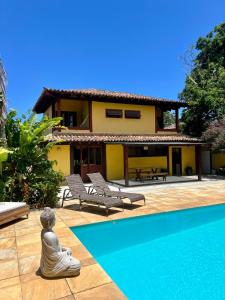 een mediterende vrouw die voor een huis zit bij Casa da Tartaruga Búzios in Búzios