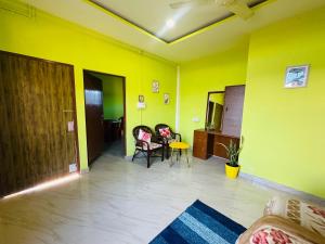 a living room with yellow walls and a couch and a table at KARDOM Homes Moran in Morānha