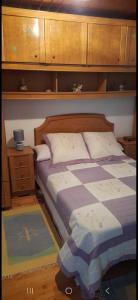 ein Schlafzimmer mit einem Bett und einem Nachttisch sowie einem 6 x 6 cm großen Bett in der Unterkunft Casa da Tita 