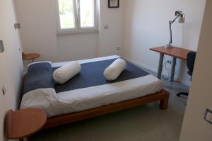 a bedroom with a bed with pillows and a desk at Casa Maria in Salerno