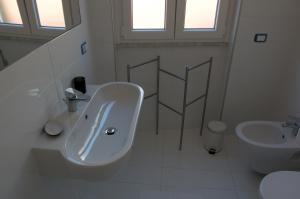 a white bathroom with a sink and a toilet at Casa Maria in Salerno