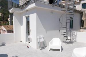 a white chair sitting on a patio next to a building at Casa Maria in Salerno