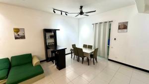 a living room with a green couch and a table at Home Vacays - B1SM1LLAH in Batu Arang