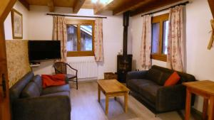 ein Wohnzimmer mit zwei Sofas und einem Flachbildfernseher in der Unterkunft Adret in Saint-Martin-de-Belleville