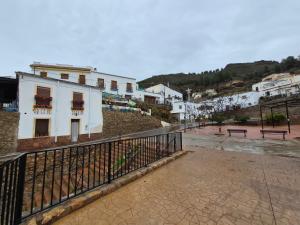 een stadsstraat met witte gebouwen en een hek bij Cortijo el Galardón 