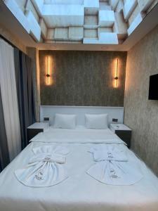 une chambre avec un grand lit avec des draps blancs dans l'établissement Royal Fsm Suites, à Istanbul 31 autres photos