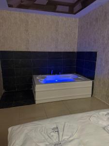 La salle de bains est pourvue d'une baignoire bleue. dans l'établissement Royal Fsm Suites, à Istanbul