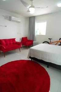 een slaapkamer met rode stoelen, een bed en een rood kleed bij Casa de Temporada in Monte Gordo +42 foto's