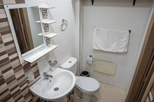 une salle de bains avec lavabo, toilettes et miroir dans l'établissement Sirajbeau miftah elkhair, à Béni Mellal 23 autres photos