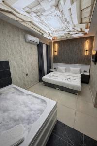 two beds in a large room with a ceiling at Royal Fsm Suites in Istanbul