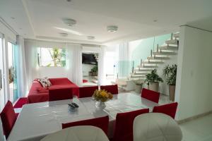 een woonkamer met een tafel en rode stoelen bij Casa de Temporada in Monte Gordo