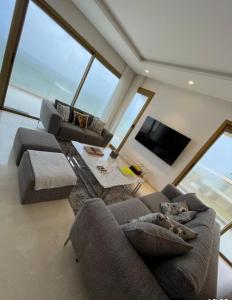 een woonkamer met twee banken en een flatscreen-tv bij Carrousel Atlantic View in Rabat +19 foto's