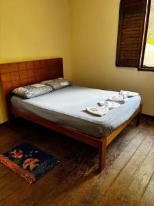 a bedroom with a bed with towels on it at Cantinho da Serra do Cipó in Santana do Riacho