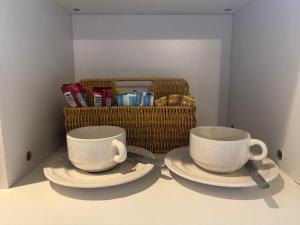 due tazze e piattini su un tavolo con un cestino di PP Place cnx 2 a Chiang Mai Altre 5 foto
