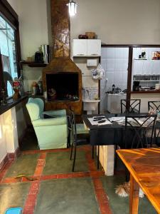 a kitchen with a living room with a fireplace at Cantinho da Serra do Cipó in Santana do Riacho