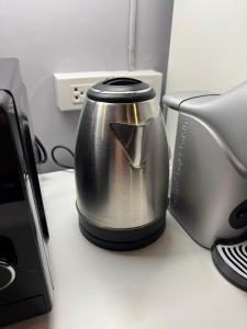 un bollitore per il tè appoggiato su una scrivania accanto a una stampante di PP Place cnx 2 a Chiang Mai