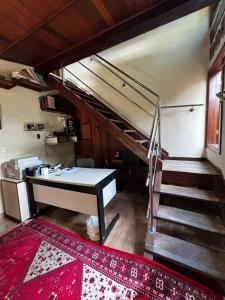 a room with a staircase and a desk in a house at Cantinho da Serra do Cipó in Santana do Riacho