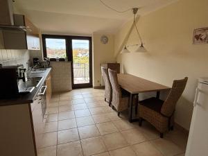 een keuken met een houten tafel en stoelen bij Ferienwohnung Gaber in Reichshof 