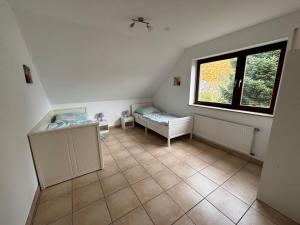 een kleine kamer met een raam en een tegelvloer bij Ferienwohnung Gaber in Reichshof 