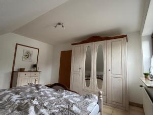 een slaapkamer met een bed en een witte kast bij Ferienwohnung Gaber in Reichshof 
