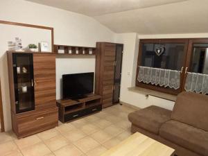 een woonkamer met een bank en een flatscreen-tv bij Ferienwohnung Gaber in Reichshof 