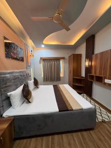 une chambre avec un grand lit avec un plafond dans l'établissement Room Racers Hotel, à Varanasi