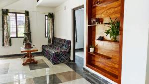 ein Wohnzimmer mit einem Sofa und einer Holztür in der Unterkunft Jessie Villas in Sultan Bathery