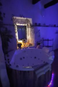 ein Badezimmer mit Badewanne und Spiegel mit Beleuchtung in der Unterkunft Il Casaletto del Terminillo in Rieti