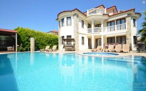a large swimming pool in front of a house at Dalyan Turaman private pool sleeps 10 in Ortaca