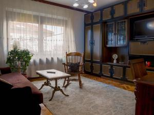 a living room with a couch and a table and a tv at Apartment Bistrik mahala in Sarajevo