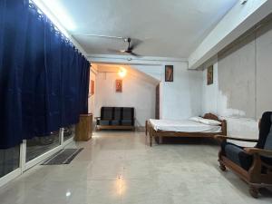 a living room with a bed and a couch at Sabari Rooms in Erumeli