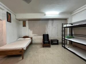 a room with two bunk beds and a chair at Sabari Rooms in Erumeli