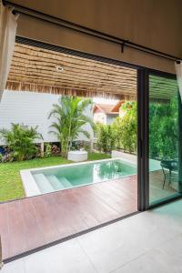 een glazen schuifdeur naar een zwembad bij Aqua Luxe in Srithanu