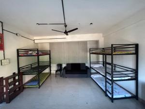 a room with three bunk beds and a ceiling at Sabari Rooms in Erumeli