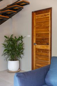 een blauwe bank en een plant voor een deur bij Aqua Luxe in Srithanu