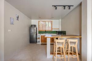 een keuken met een houten tafel en stoelen bij Aqua Luxe in Srithanu