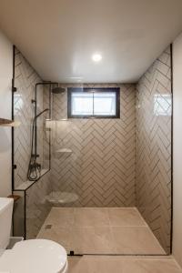 een badkamer met douche, toilet en raam bij Aqua Luxe in Srithanu +8 foto's